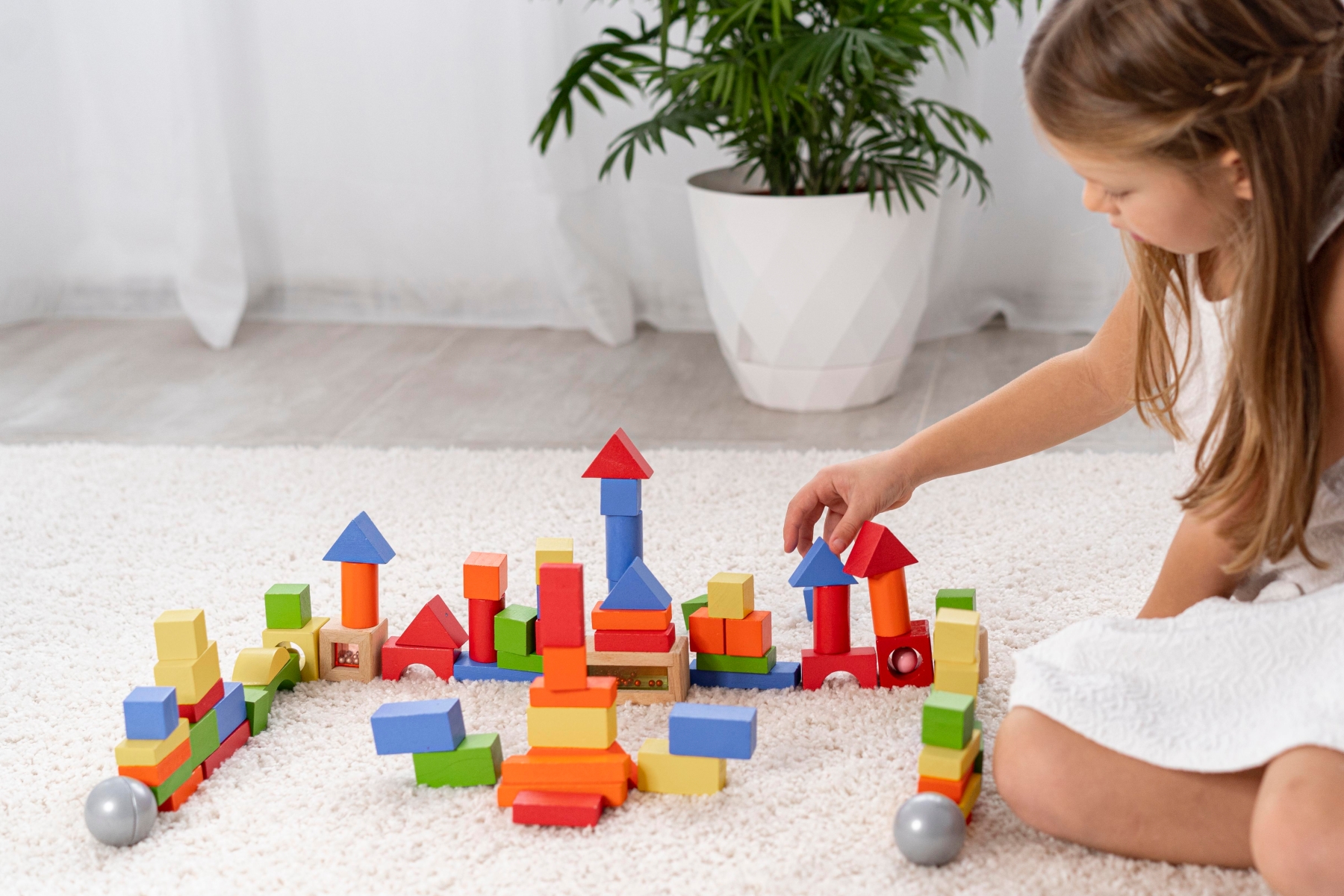 non bimary kid playing with colorful wooden toys